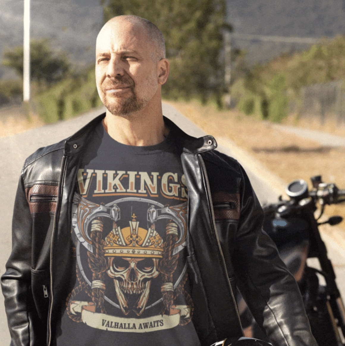 Bald biker man with a goatee in a black leather jacket wearing a VIKINGS t-shirt